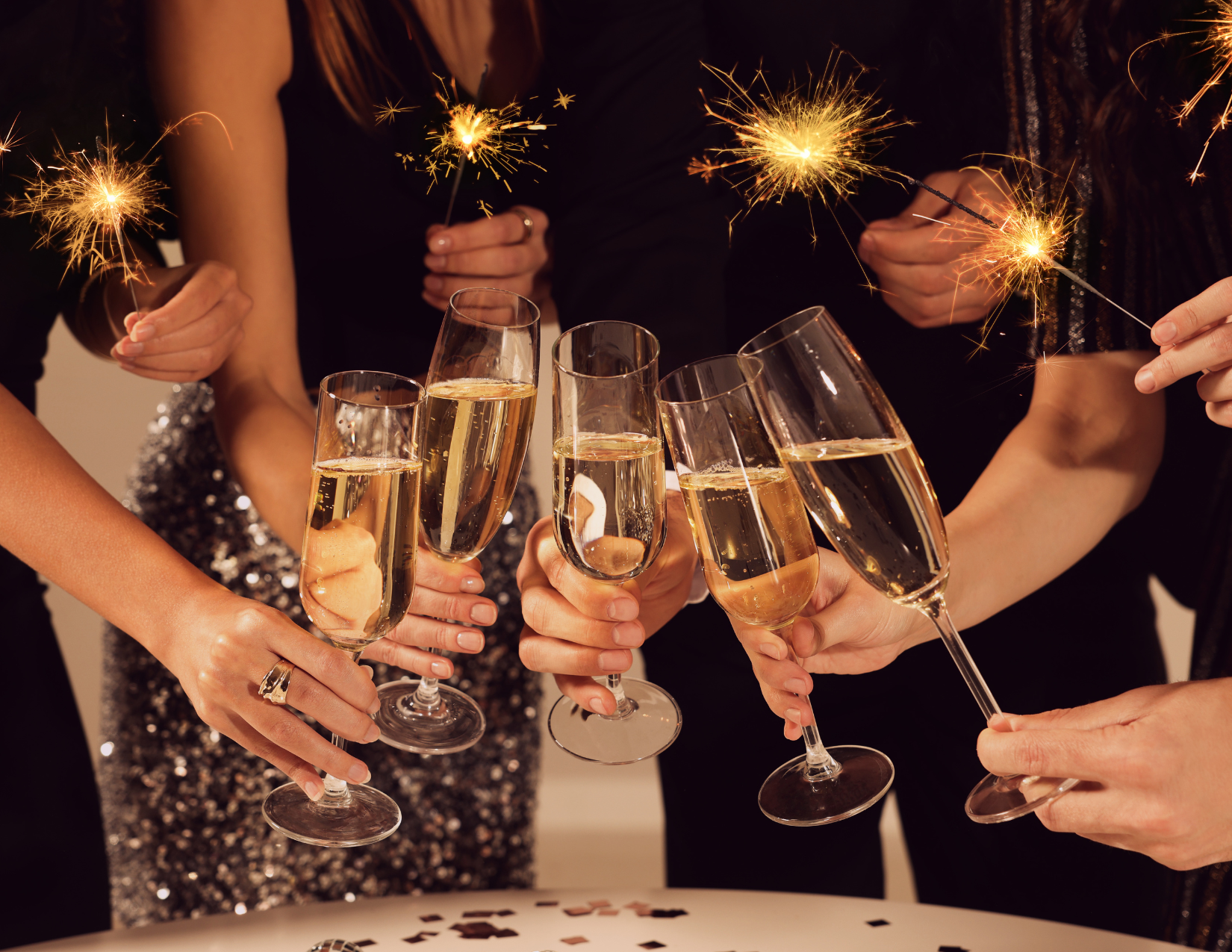 a group of people doing a cheers with sparkling wine for a sparkling wine tasting event at Le Macaron Fishers December 29, 2023 at 8 pm. Buy tickets now!