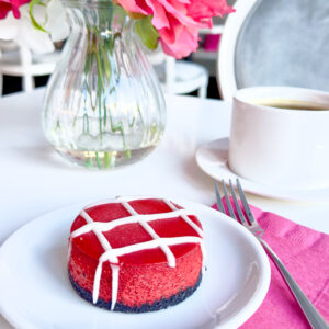 red velvet cheesecake on chocolate cookie crust drizzled with cream cheese