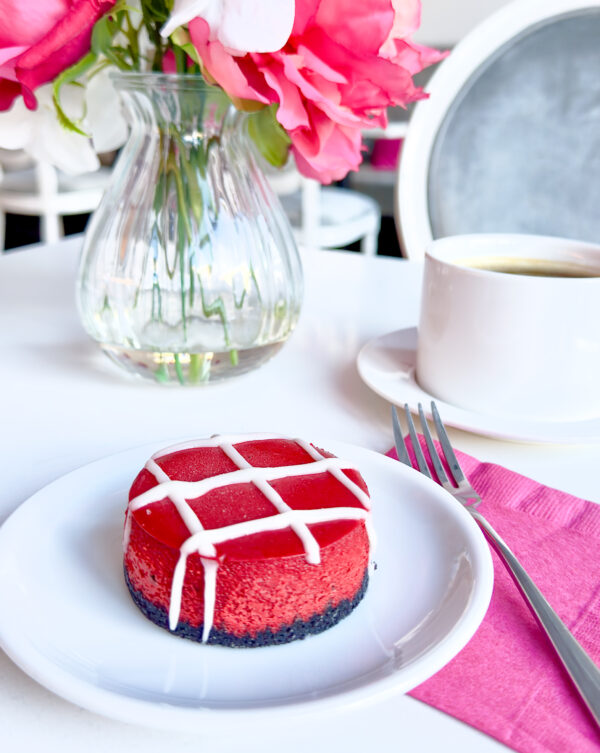 red velvet cheesecake on chocolate cookie crust drizzled with cream cheese