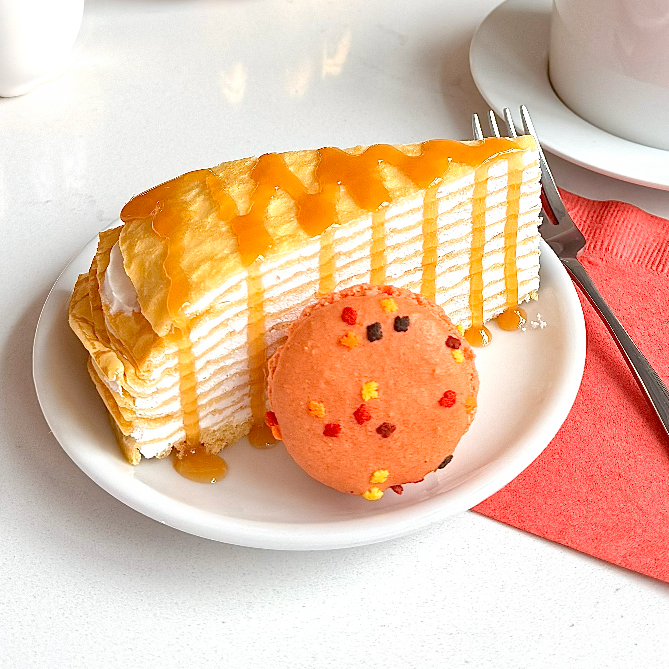 vanilla crepe cake drizzled with caramel and paired with a macaron